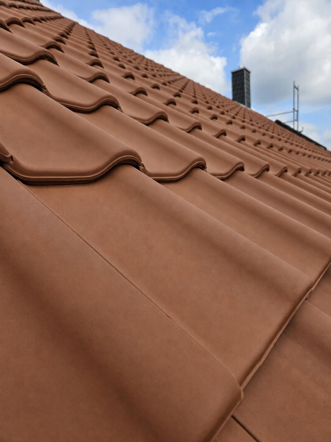 Detailaufnahme frisch verlegter roter Dachziegel