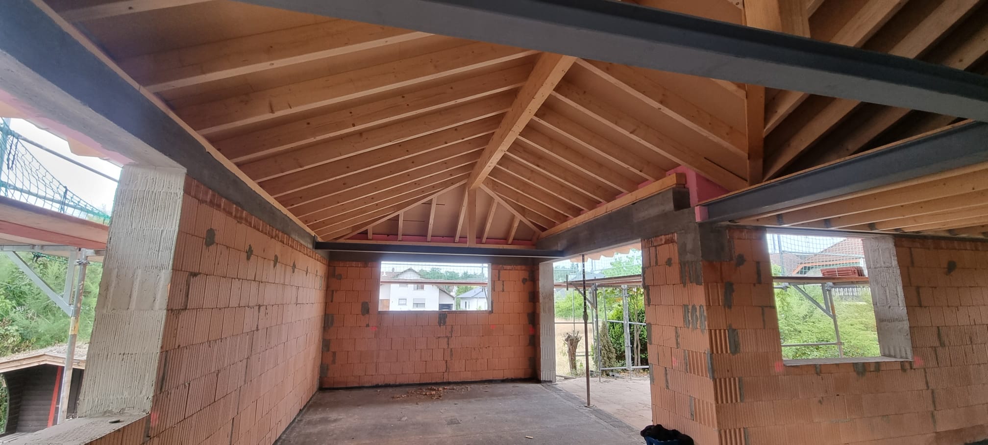 Neu errichteter Dachstuhl aus Holz über einem Rohbau